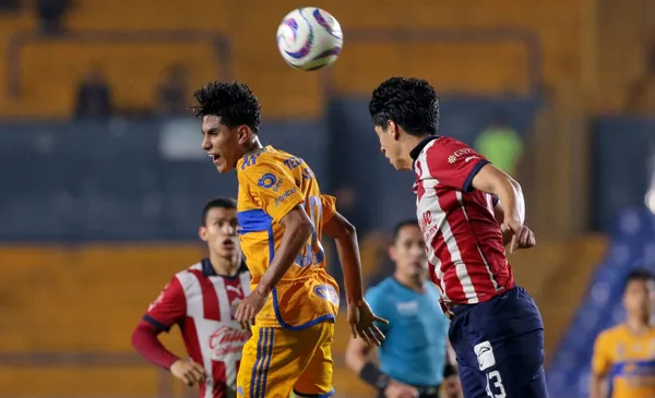 Jugadores de Chivas y Tigres pelean una pelota por aire (Fuente: Mexsports)