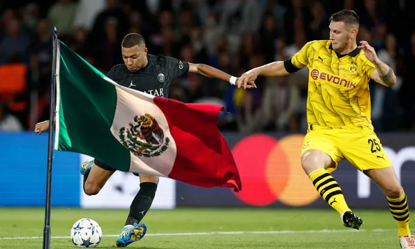 Mbappé patea una pelota mientras jugador del Borussia lo marca / Reuters