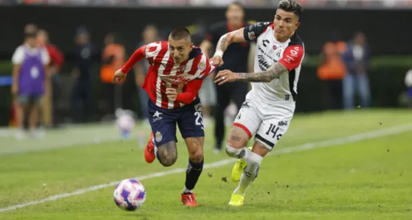 Roberto Alvarado le gana una pelota al Hueso Reyes (Fuente: Mexsports)