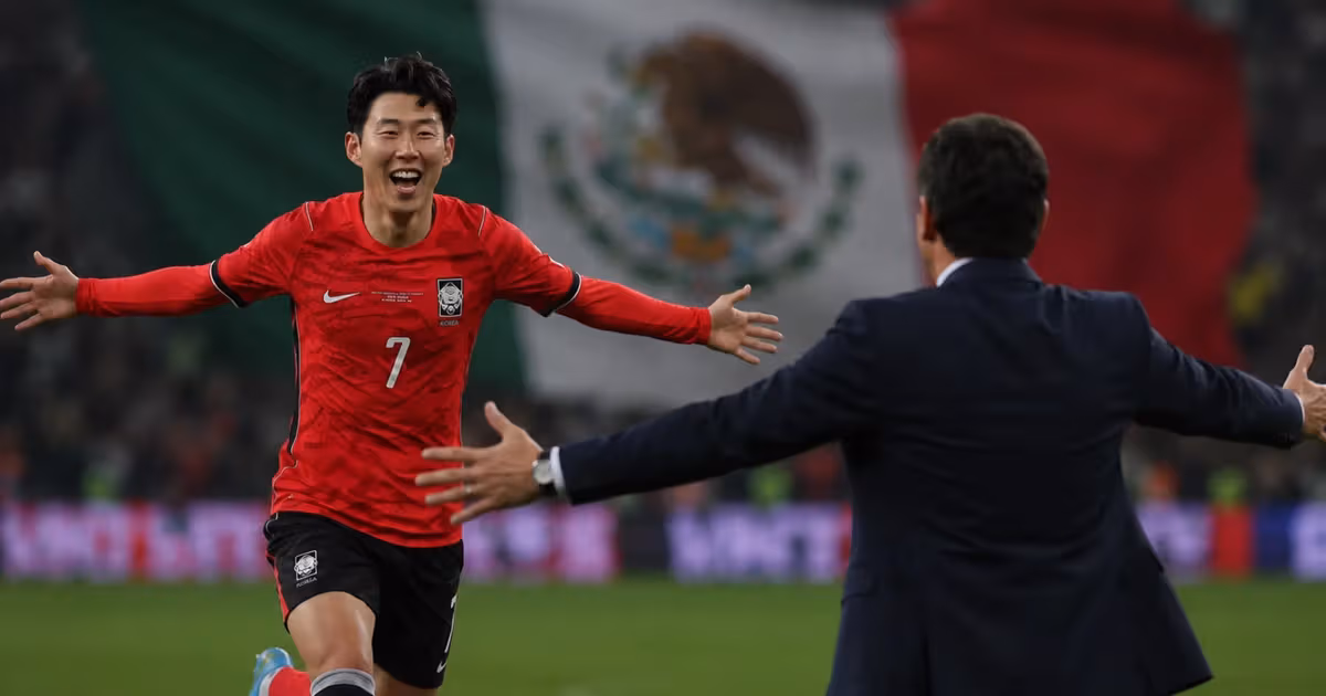 Son Heung-Min yendo a abrazar a Andrés Guardado.