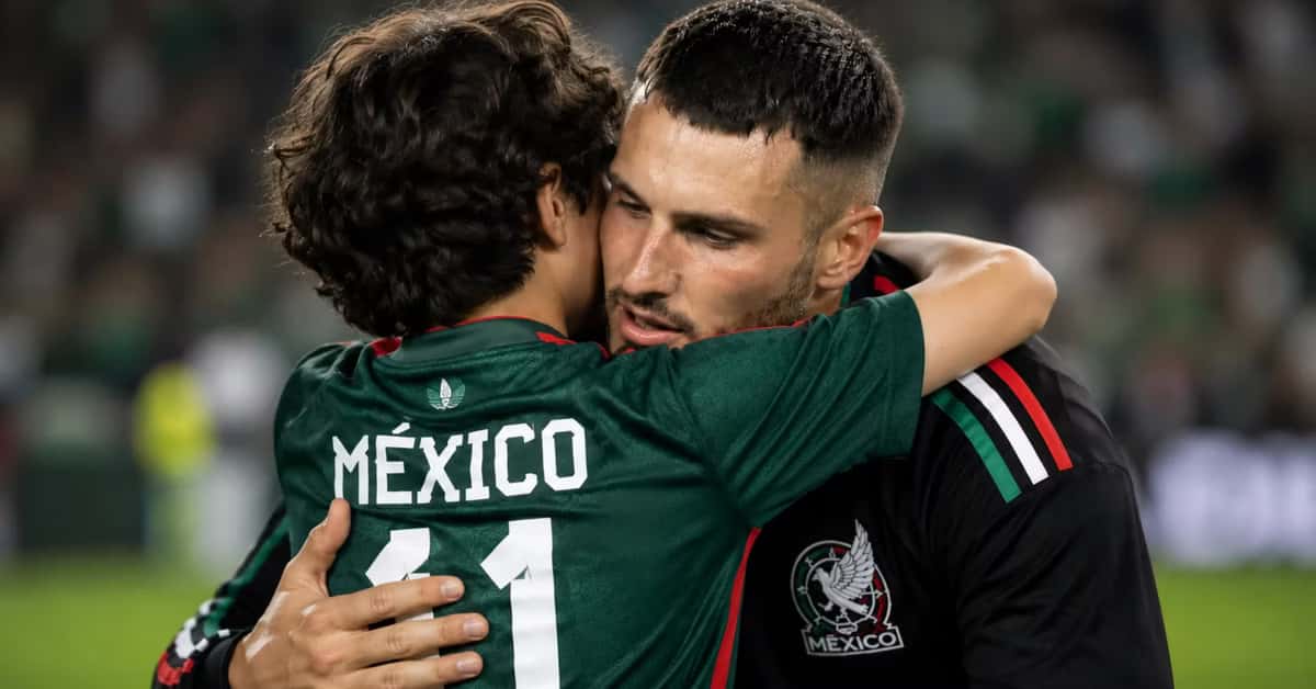 Santiago Giménez abrazando a un pequeño