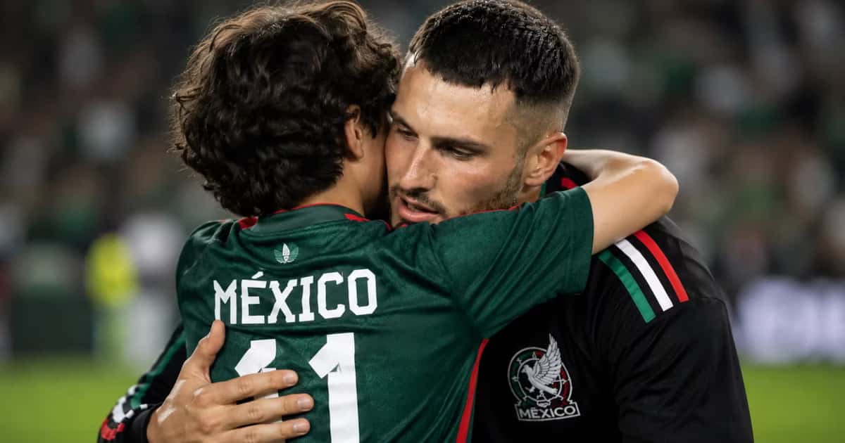 Santiago Giménez abrazando a un pequeño
