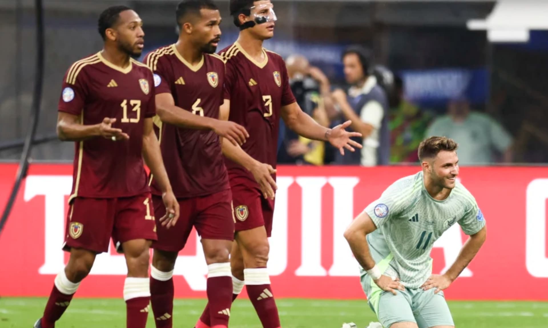 Santiago Giménez de rodillas ante tres jugadores de Venezuela (Fuente: Reuters)