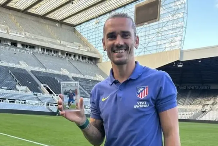 Griezmann presumiendo su valioso cromo de Lionel Messi
